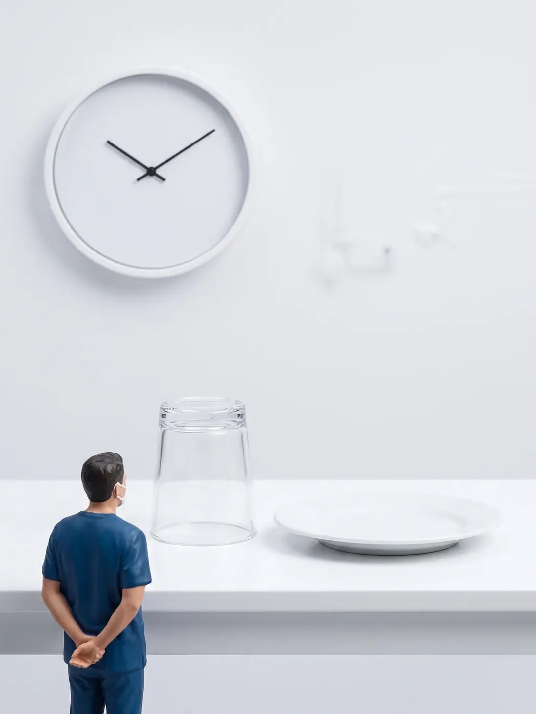 Un vaso boca abajo y un plato vacíos bajo un reloj de esfera lisa sin cifras, con un profesional esperando, para explicar el ayuno previo a la sedación infantil, para pacientes de Toluca